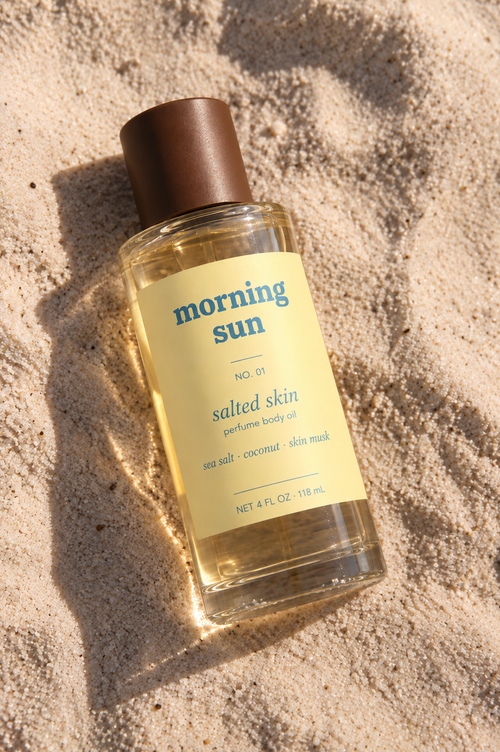 Morning Sun Salted Skin perfume body oil, no. 01, lying in warm beach sand