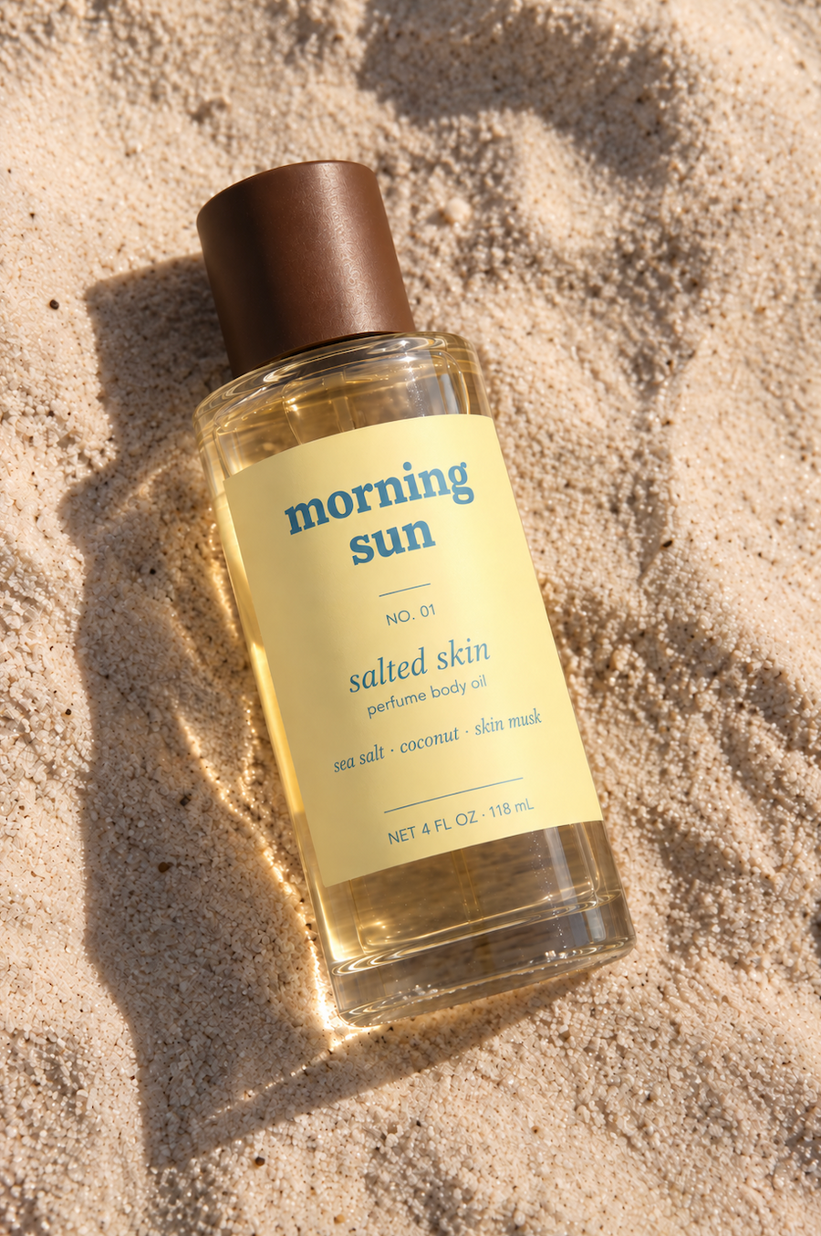 Morning Sun Salted Skin perfume body oil, no. 01, lying in warm beach sand