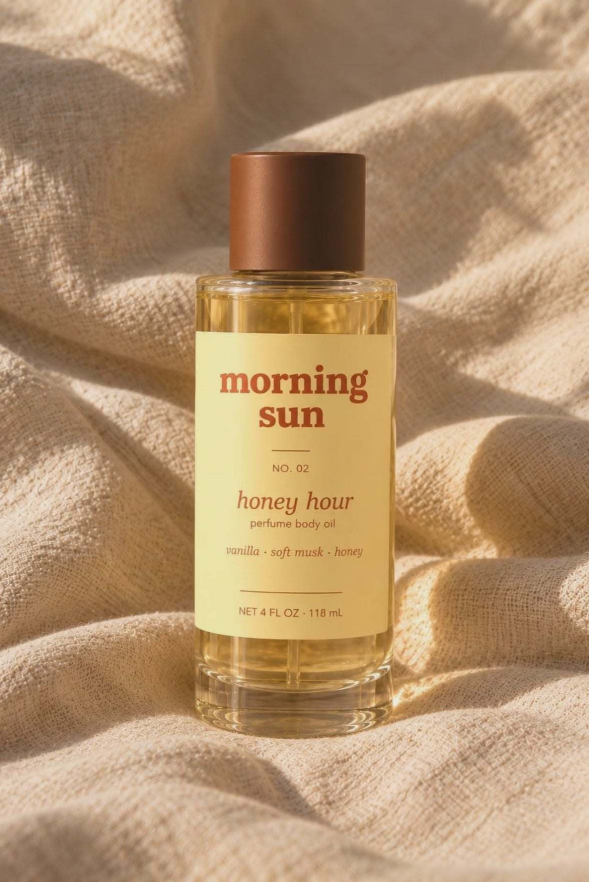 Honey Hour perfume body oil, no. 02, on rumpled linen in warm golden-hour light